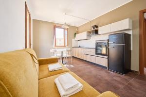 a living room with a couch and a kitchen at Casa La Polledraia in Venturina Terme