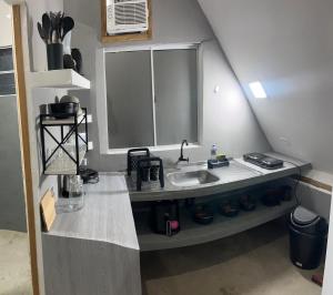 a kitchen with a sink and a counter top at Condomíno dos Chalés in Porto Seguro