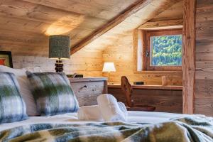 a bedroom with a bed and a window in a cabin at chalet in authentic Manigod farm in Manigod