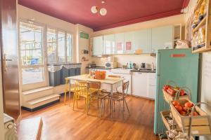 a kitchen with white cabinets and a table and chairs at Ostello Bello Roma Colosseo in Rome