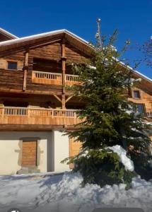 a log home with a tree in front of it at chalet in authentic Manigod farm in Manigod