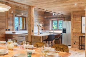 a kitchen with a table with chairs and a refrigerator at chalet in authentic Manigod farm in Manigod +38 photos