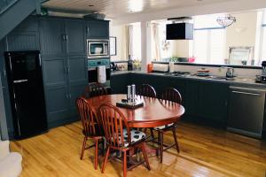 a kitchen with green cabinets and a wooden table and chairs at The Old Court House & Jail in Menai Bridge