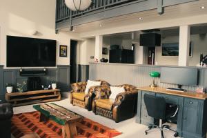 a living room with two couches and a television at The Old Court House & Jail in Menai Bridge