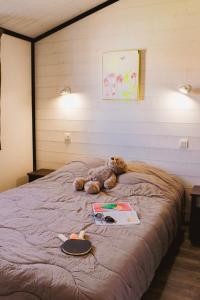 a teddy bear laying on top of a bed at Le Clos des Soulacaises in Soulac-sur-Mer +28 photos