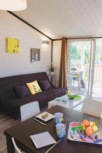 a living room with a couch and a table at Le Clos des Soulacaises in Soulac-sur-Mer