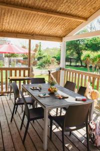 a wooden table and chairs on a deck at Le Clos des Soulacaises in Soulac-sur-Mer