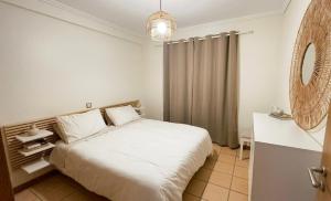 a bedroom with a white bed and a mirror at Casa Sol e Praia in Porto Santo