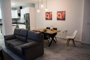 a living room with a couch and a dining room table at Sylvia Apartman in La Mata