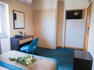 a hotel room with a bed and a desk and a chair at Hotel DAH - Dom Afonso Henriques in Lisbon