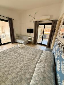 a bedroom with a large bed and a television at B&B Le Farfalle in Palau