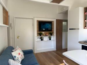 a living room with a blue couch and a tv at Maison Louis in Parma