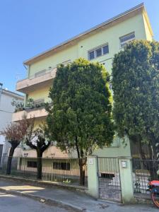 a building with trees in front of a fence at Maison Louis in Parma