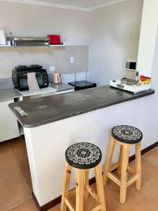 a kitchen with two stools sitting at a counter at Monoambiente PIPE in Bella Vista +15 photos