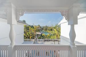 a white balcony with a view of a pool at Lanna Inthan Hotel & Resort in Doi Saket