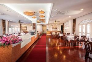 a restaurant with a dining room with tables and chairs at Lanna Inthan Hotel & Resort in Doi Saket