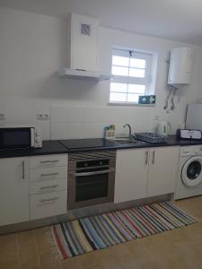 a kitchen with a sink and a stove top oven at Casa FIGUEIRAS in Bensafrim