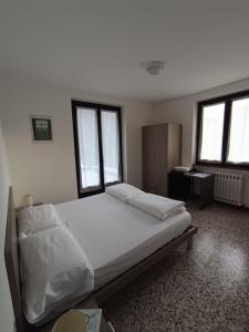 a bedroom with a large bed with two windows at Albergo Bellavista in Re
