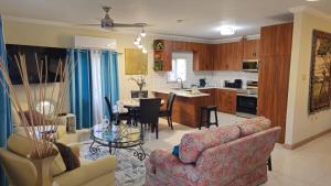 a living room and kitchen with a couch and a table at The Full Maison at Ocho Rios in Ocho Rios