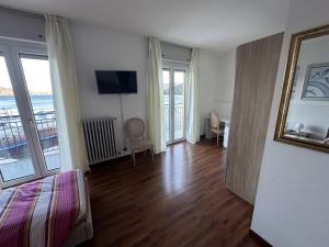 a bedroom with a bed and a room with a balcony at Hotel Capri in Lesa