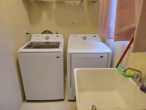 a small kitchen with a stove and a washer and dryer at The Full Maison at Ocho Rios in Ocho Rios