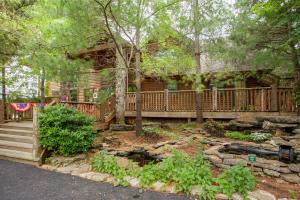 a log cabin with a porch and a garden at 2BR Village At Indian Point 501 near SDC-Free Tickets Daily up to $500 in Branson