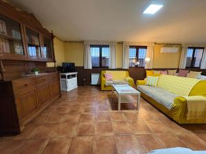 a living room with two yellow couches and a kitchen at Casa La Bienvenida con patio y aparcamiento - Apartamentos Aloha Toledo in Nambroca