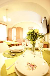 a table with plates and glasses and a vase with flowers at Apartmány v Centru in Třeboň