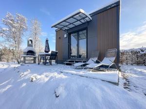 a house in the snow with a table and chairs at Feriendorf Seeblick - Tiny Nr 11 in Neunburg vorm Wald
