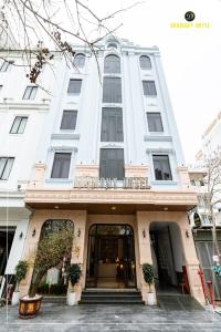 a large white building with a entrance to it at Harmony Hotel Nam Định in Như Thức