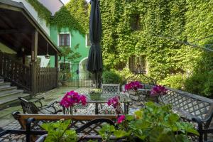 a patio with a table and an umbrella and flowers at Apartmány v Centru in Třeboň