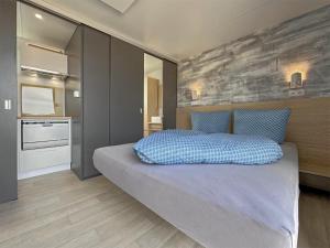 a bedroom with a bed with a blue pillow on it at Feriendorf Seeblick - Tiny Nr 11 in Neunburg vorm Wald