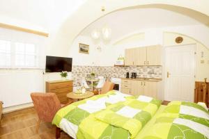 a bedroom with a large bed and a kitchen at Apartmány v Centru in Třeboň
