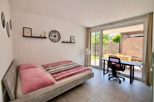 a bedroom with a bed and a desk and a clock at Zentrales Apartment in Friedrichshafen mit Terrasse für bis zu 5 Personen in Friedrichshafen