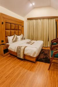 a bedroom with a large bed and a chair at The Heritage Chinar by Ackee Tree in Srinagar