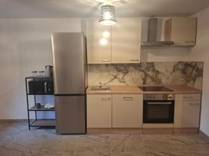 a kitchen with a stainless steel refrigerator and a sink at Jinn's Valley Apartment in Grižane