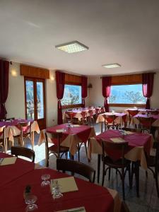 a dining room with red tables and chairs and windows at Albergo Bellavista in Re +45 photos