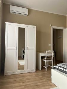 a bedroom with a white closet and a desk at Dimora Stadio Biella in Biella
