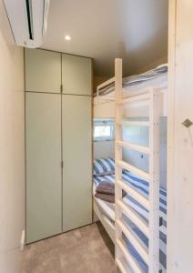 a bedroom with bunk beds and a closet at De Lepelaar - Ecohuisjes Terschelling in Midsland