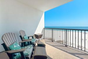 a balcony with chairs and a view of the beach at The Palms West Unit 515 in Orange Beach