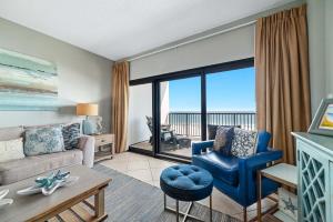 a living room with a couch and chairs and a large window at The Palms West Unit 515 in Orange Beach