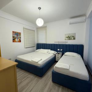 two beds in a room with blue and white at Sofia's Holiday Apartment in Vlorë +68 photos
