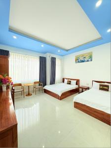a hotel room with two beds and a table at ĐỨC THẠNH HOTEL in Rạch Giá +23 photos