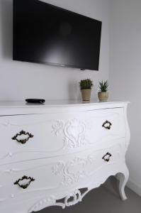 eine weiße Kommode mit einem TV darüber in der Unterkunft A Casa di Anna in Neapel