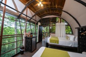 a room with two beds in a tree house with windows at Maquenque Lodge in Boca Tapada +95 photos