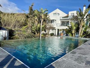 a swimming pool in front of a house at Harmony Deluxe Accommodation in Água de Pau