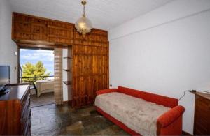 a living room with a red couch and a television at GM View Oropos in Oropos