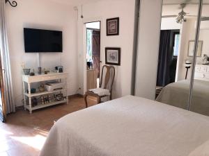 a bedroom with a bed and a tv on a wall at La calade in Roquefort-les-Pins