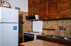 a kitchen with a stove and a white refrigerator at GM View Oropos in Oropos