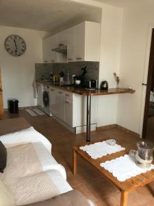 a kitchen with a table and a clock on the wall at La calade in Roquefort-les-Pins